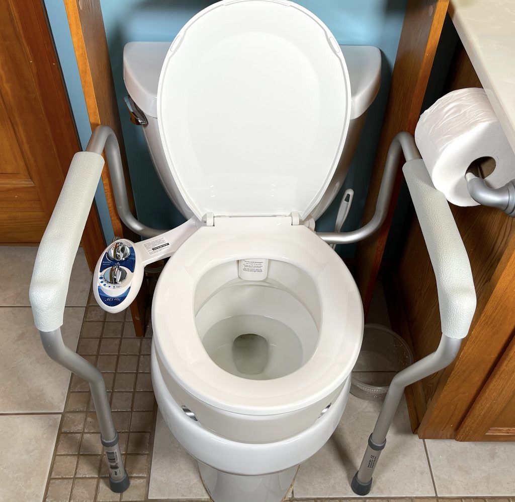 A bidet install with a raised toilet seat