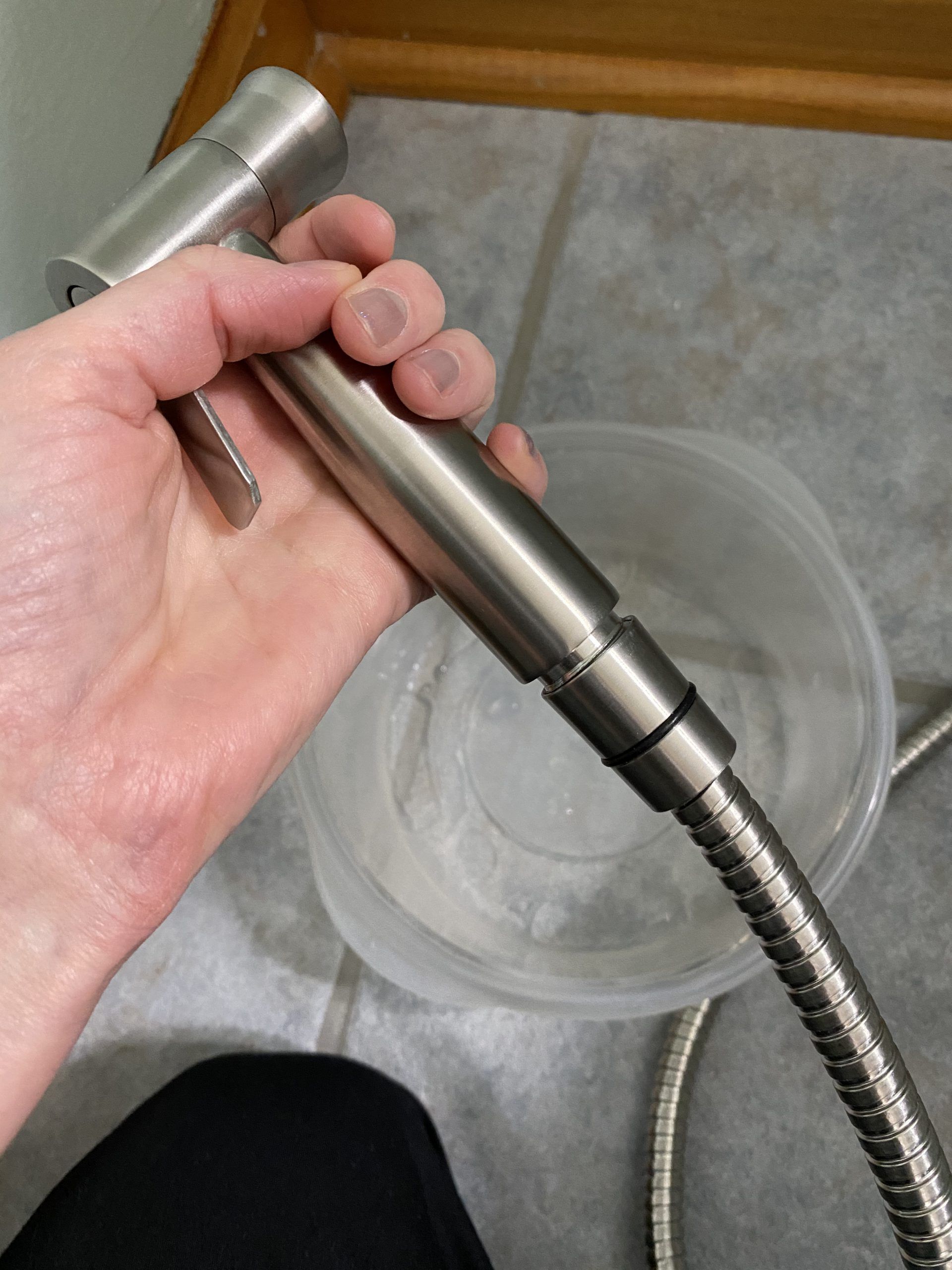 Handheld bidet sprayer attached to hose.
