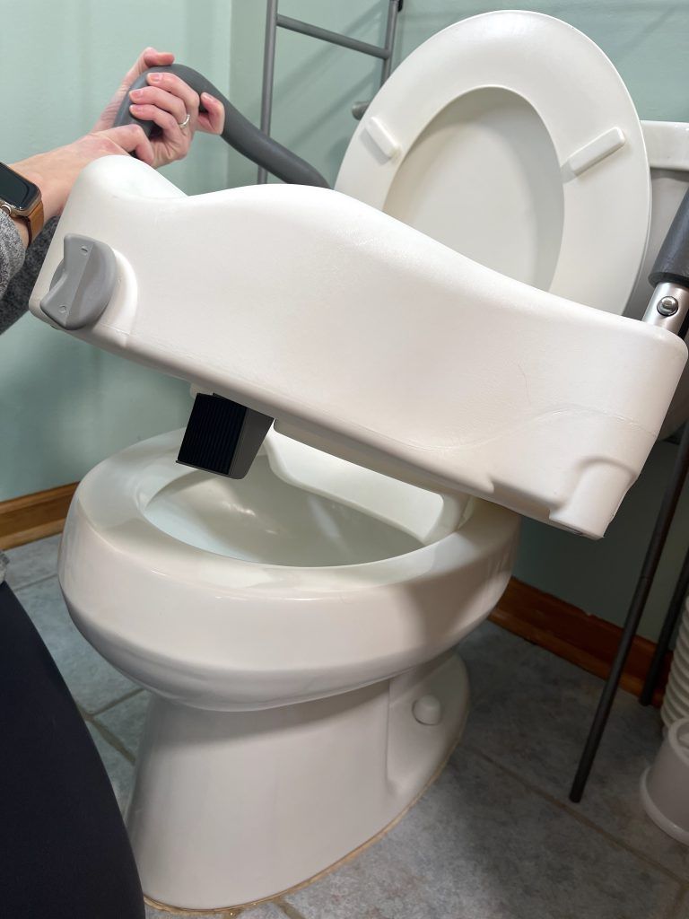 Place back first into toilet bowl - clamp-on raised toilet seat